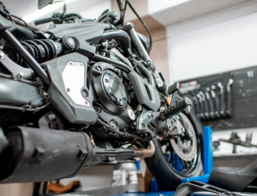 Close-up of a sports motorcycle standing on a lift during the maintenance at the workshop